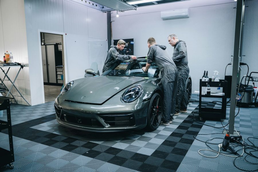 a group of men working on a car in a garage