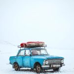 blue sedan on snow ground